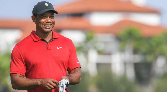 Tiger Woods smiling on a golf course, Photo Credit: Nick T. White/X