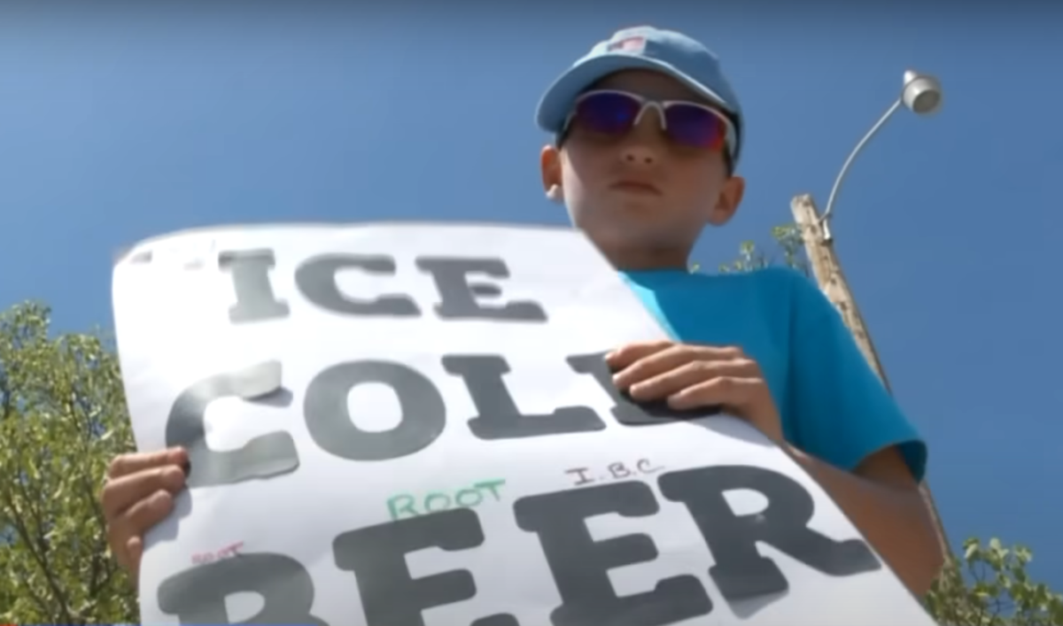 Seth Parker posing with his "ice cold beer" sign, Photo Credit: FOX 13 News Utah/Youtube