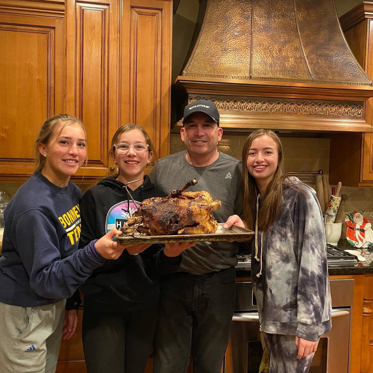 Richard David Hendrickson posing with his daughters in front of a cooked bird, Photo Credit: Richard Hendrickson/Facebook