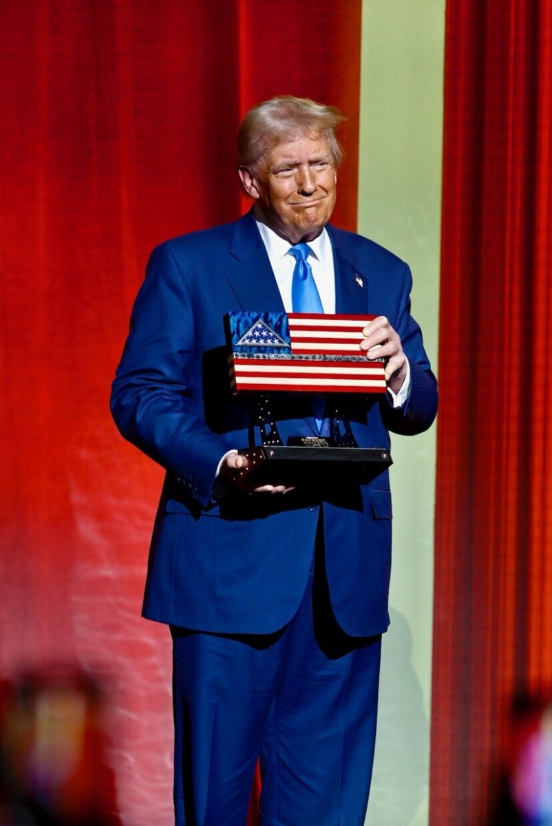 President Trump holding an American flag item in his hands, Photo Credit: Donald J. Trump/Truth Social