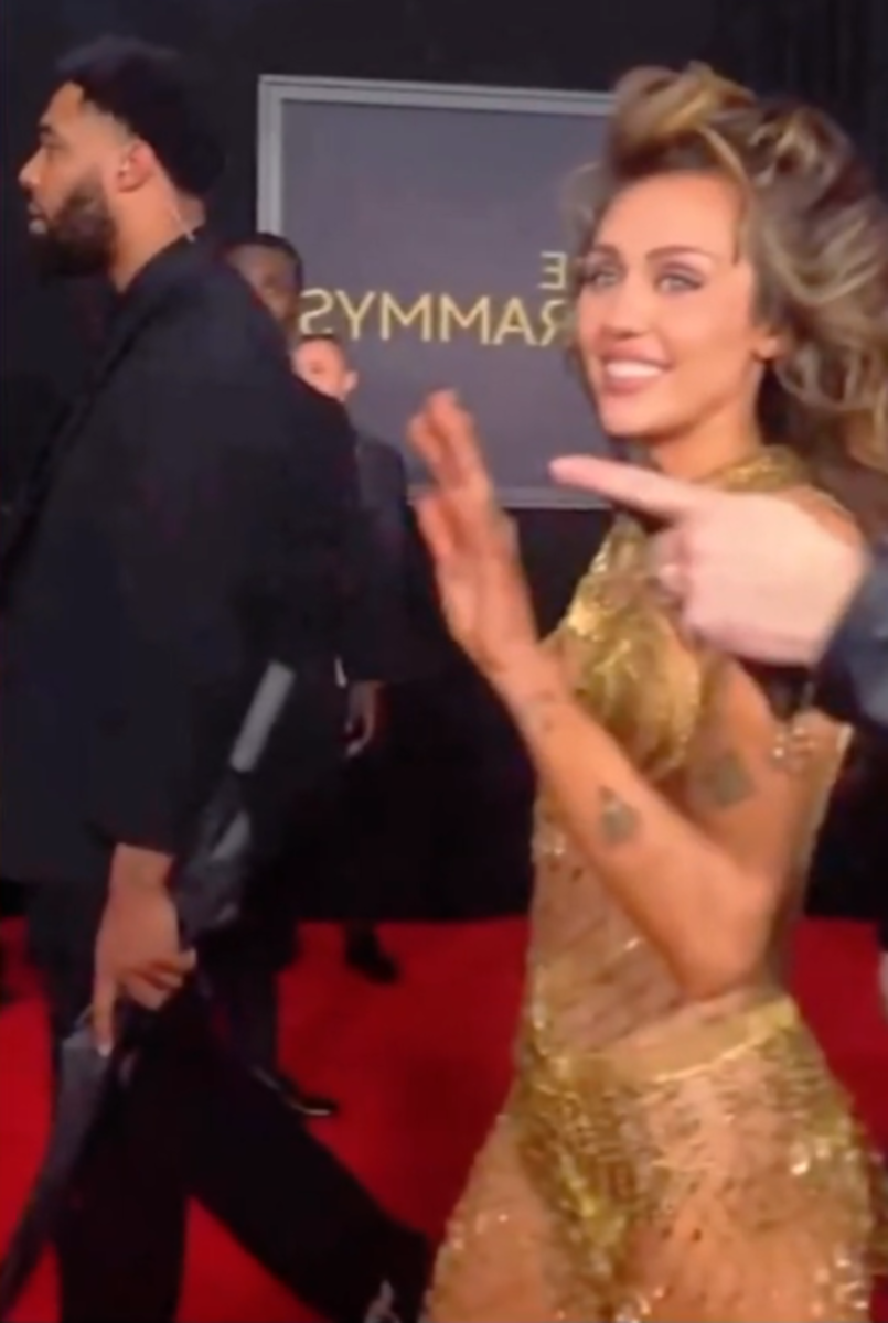 Miley Cyrus walking the GRAMMYs red carpet alongside her bodyguard, Photo Credit: alienthemartian/youtube