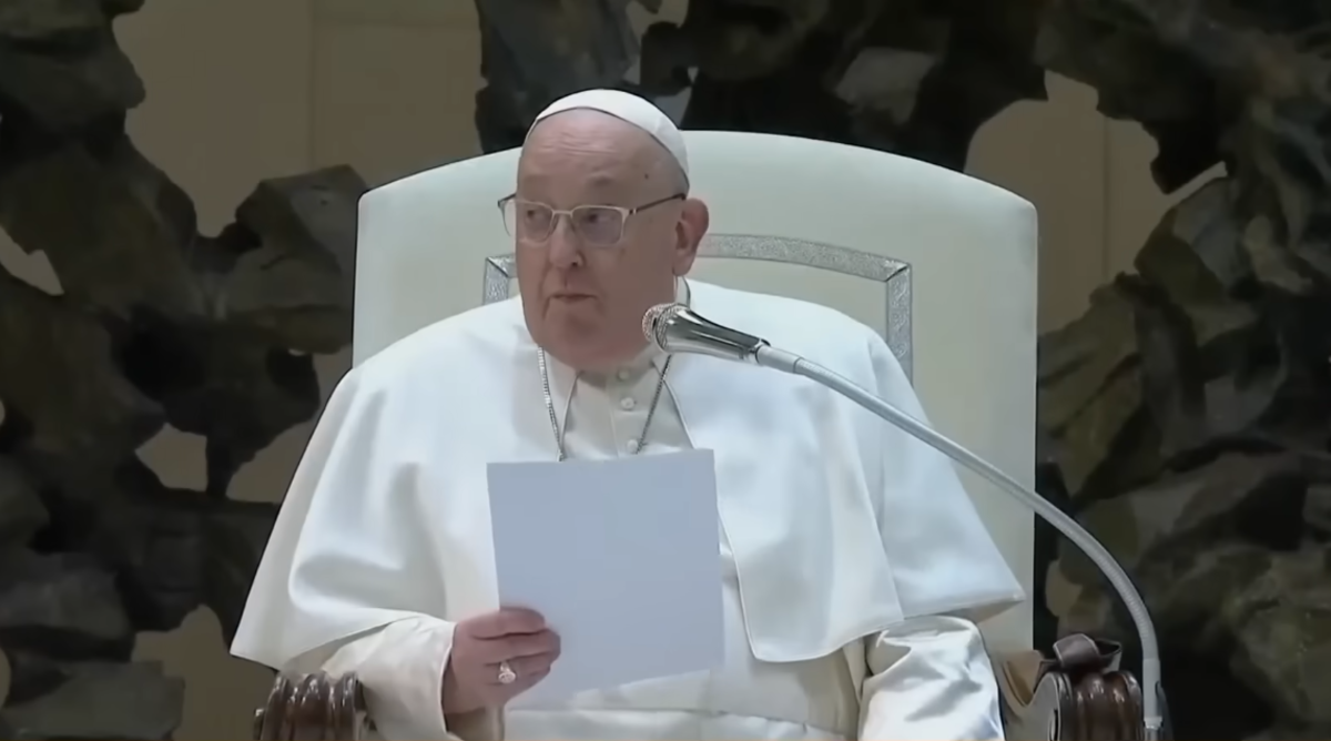 Pope Francis sitting down while holding a paper in front of a mic, Photo Credit: Today